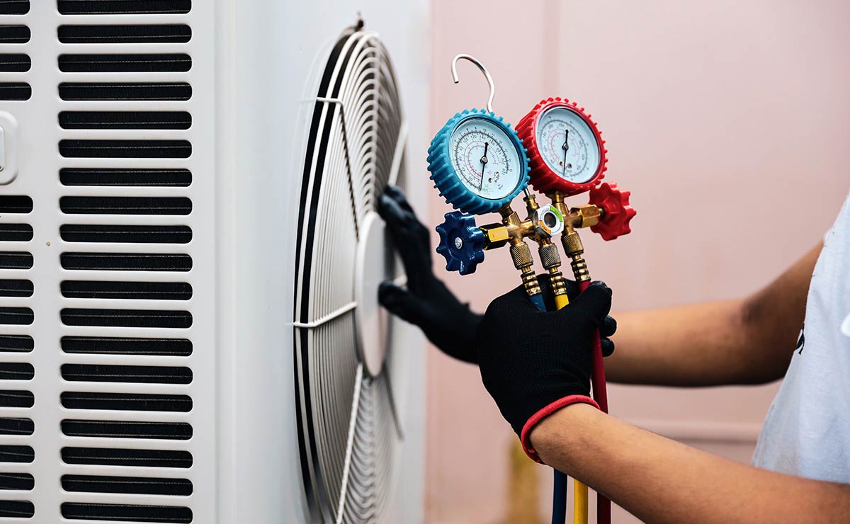 HVAC service technician checking AC unit using manometer gauge